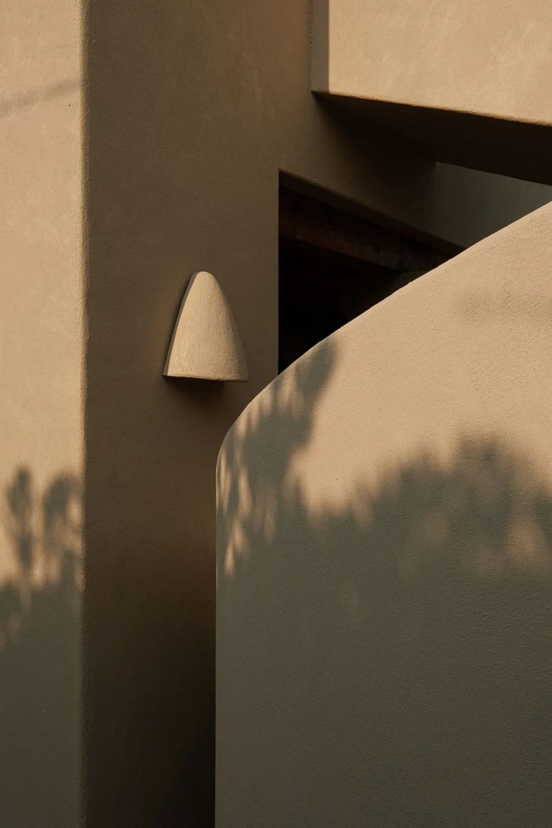Warm KERAI wall light on a lime wall